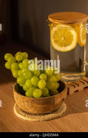 Grüne Trauben liegen auf Öko-Gericht. Umweltfreundliche Wahl und freundliche Natur. Das Konzept der Welt ohne plastikfreien und sauberen Planeten. Umweltfreundliches Geschirr aus natürlichen Materialien Stockfoto