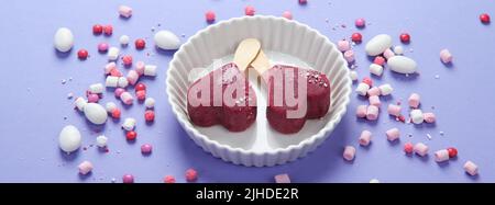 Violettes Heidelbeer-Eis auf lilafarbenem Hintergrund. Stimmungsvolles, süßes Menükonzept. Panorama Stockfoto