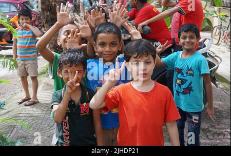Indische Kinder lächeln und unterzeichnen einen Sieg in der Feier, Mumbai, Maharashtra Staat, Indien - August 2016 Stockfoto