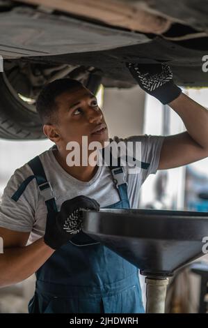 Erfahrener Autoreparaturarbeiter, der ein Problem mit dem Auto diagnostizierte Stockfoto