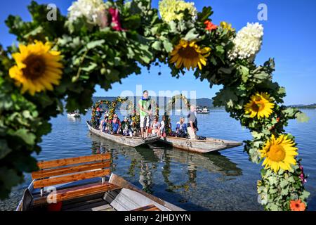 Radolfzell Am Bodensee, Deutschland. 18.. Juli 2022. Mit Blumenkränzen geschmückte Boote fahren während der Moos Wasserprozession über den Bodensee zum Ufer von Radolfzell. Die Prozession fand erstmals 1926 auf dem Wasser über den Bodensee statt. Es stammt aus dem 18.. Jahrhundert. 1796 wurden die Bürger von Moos von einer Viehpest verschont - aus Dankbarkeit dafür findet die Veranstaltung jedes Jahr am dritten Montag im Juli statt. Quelle: Felix Kästle/dpa/Alamy Live News Stockfoto