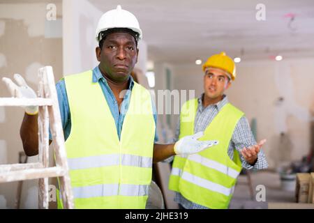 Vorarbeiter unzufrieden mit der Qualität der Reparaturarbeiten der Baumeister Nahaufnahme Stockfoto