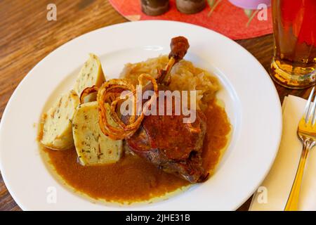 Die Entenschenkel mit Sauerkraut und Knödeln bepüren Stockfoto