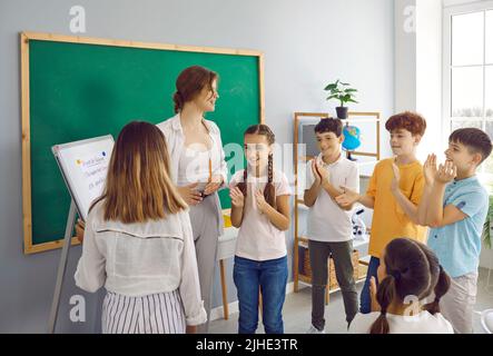 Kinder in der Grundschule lernen in kreativem Unterricht, indem sie mit dem Lehrer spielen. Stockfoto