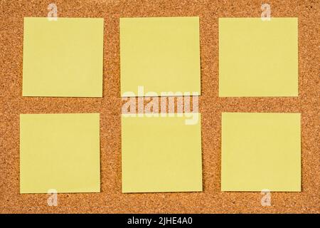 Sechs leere gelbe Haftnotizen auf einem Korkbrett, kopieren Sie vorbei Stockfoto