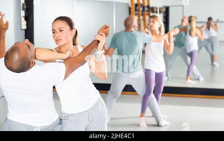 Frau und Mann beim Selbstschutztraining, Training der Angriffsbewegungen Stockfoto