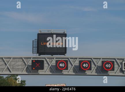 Ein intelligentes Autobahnschild, das die nationale Geschwindigkeitsbegrenzung angibt, ist auf 40 Meilen pro Stunde beschränkt, und eine Spur ist gesperrt, Fahrspur verboten Stockfoto