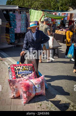Ein älterer Mann wartet mit einem Nedding, der auf dem Sonntagsmarkt Souk, einem Wochenmarkt in Souse, Tunesien, gekauft wurde. Stockfoto