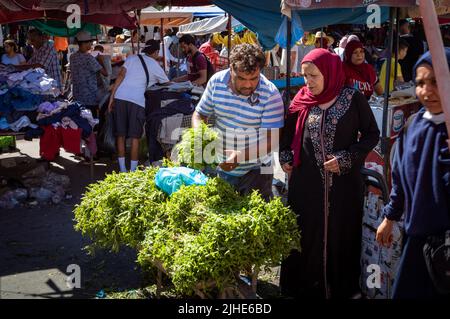 Eine Frau kauft frische Minze im Sonntagsmarkt Souk, einem Wochenmarkt in Sousse, Tunesien. Stockfoto