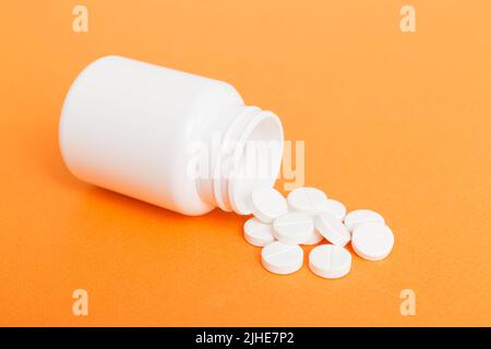 Verschiedene Medikamente und Nahrungsergänzungsmittel Pillen gegossen aus einer Medikamentenflasche Gesundheitsversorgung und medizinische Draufsicht auf farbigen Hintergrund. Stockfoto