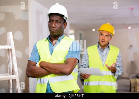 Vorarbeiter unzufrieden mit der Qualität der Reparaturarbeiten der Baumeister Nahaufnahme Stockfoto