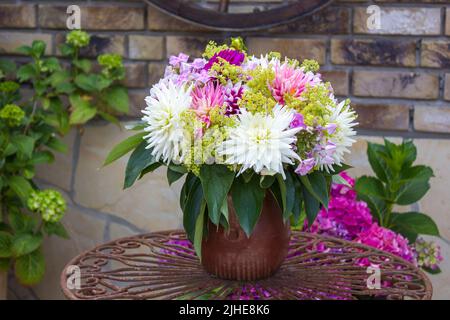 Strauß Dahlien in einer Vase auf einem Gartentisch Stockfoto