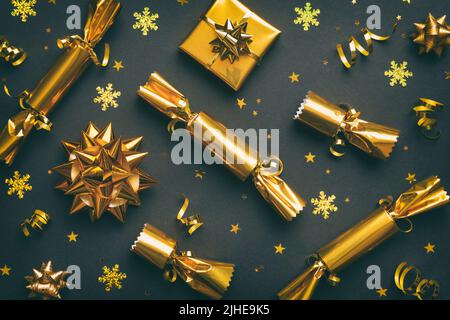 Weihnachtscracker mit glänzendem Konfetti auf farbigem Hintergrund, Draufsicht, Kopierraum. Stockfoto