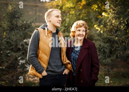 Mutter und Sohn blicken in die Ferne im Wald zwischen den Bäumen im Freien Stockfoto