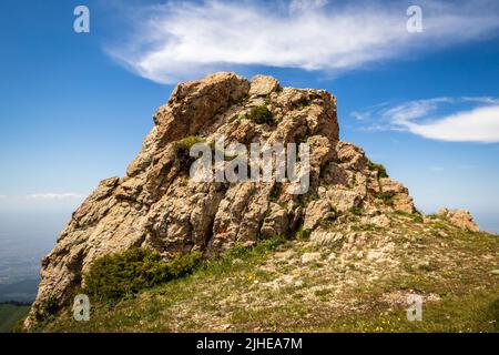 Ein großer Felsbrocken auf 3 Brüdern, mit einem Hut aus Wolken., ein beliebter Wanderweg in der Nähe von Almaty Stadt Stockfoto