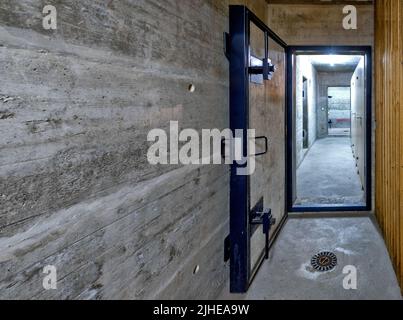 Gepanzerte Tür eines öffentlichen Fallout-Schutzhauses in einem Mehrfamilienhaus in der Schweiz Stockfoto