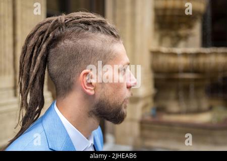 Porträt im Profil eines kaukasischen Mannes mit Dreadlocks Stockfoto