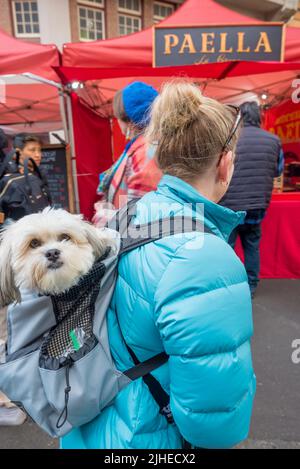 16. Juli 2022: Cindy aus dem Hills Shire in Sydney betrachtet die Paella mit ihrem Hundebegleiter im Rucksack an Weihnachten im Juli, Rocks Markets Stockfoto