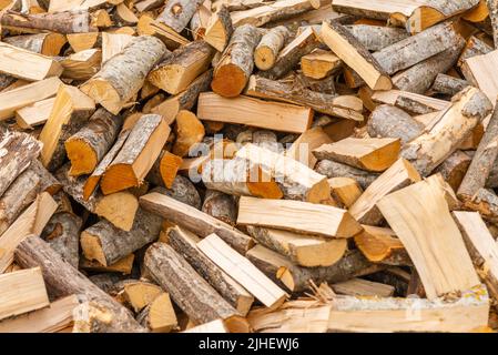 Ein Stapel gestapeltes Brennholz, vorbereitet für die Heizung des Hauses. Brennholz für die fertige Heizung im Winter.gehacktes Brennholz.Umwelt Hintergrund. Stockfoto