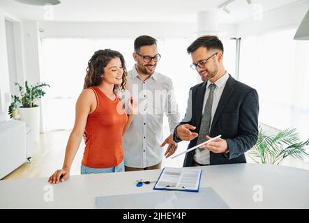 Paar Haus Immobilienmakler Heim Tablet Technologie Geschäft Kauf Investition Immobilien Wohnung Showroom Vertrag Schlüssel compter Stockfoto