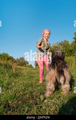 Kleines Mädchen umarmt spielen mit Hund im Freien. Familienspaziergängen Spaß haben Zeit zusammen in der Natur zu verbringen. Kind mit Haustier Freund auf Sommerwiese. Acti Stockfoto