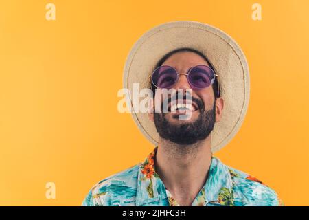 Nahaufnahme eines jungen Mannes mit moderner Sonnenbrille und Sommerkleidung, der seinen Kopf über orangefarbenen isolierten Hintergrund schüttelt, vertikale Studioaufnahme. Hochwertige Fotos Stockfoto