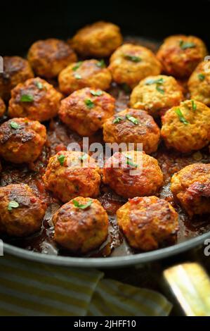 Nahaufnahme Fleischbällchen und Tomatensauce in Pfanne auf dem Tisch Stockfoto