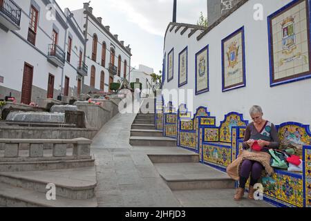 Promenade Paseo de Canarias mit Keramikfliesen, Kanarierin auf kunstvoller Bank sitzend und strickt, Firgas, Grand Canary, Kanarische Inseln, Spanien, Europa Stockfoto