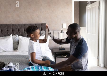 Das Bild eines afroamerikanischen Vaters hilft seinem Sohn, sich zu verändern Stockfoto