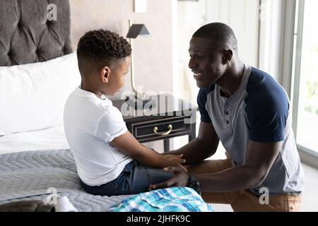 Das Bild eines afroamerikanischen Vaters hilft seinem Sohn, sich zu verändern Stockfoto