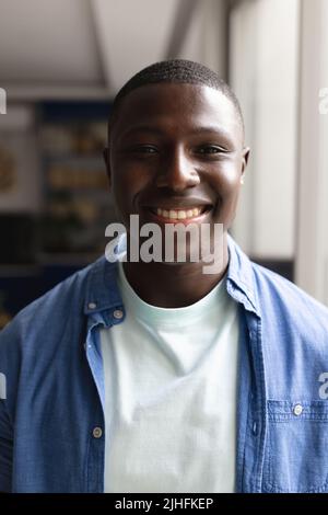 Vertikales Porträt eines glücklichen afroamerikanischen Mannes, der die Kamera anschaut Stockfoto
