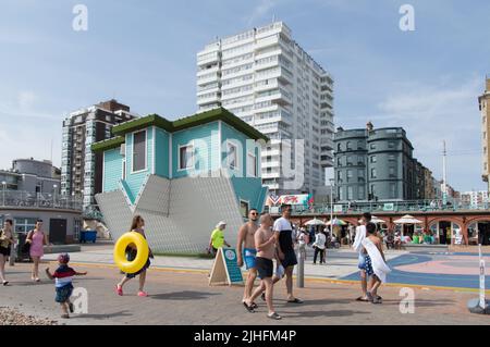 Menschen, die an dem umgekehrten Haus in der Brighton Beach Heatwave 2022 vorbeilaufen Stockfoto