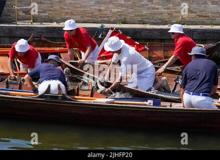 Swan-Ups checken über ein Cygnet in der Nähe von Staines-upon-Thames in Surrey, während der alten Tradition des Swan Upings, der jährlichen Zählung der Schwanenpopulation an der Themse. Bilddatum: Montag, 18. Juli 2022. Stockfoto