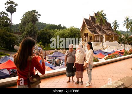 (220718) -- VIENTIANE, 18. Juli 2022 (Xinhua) -- Touristen posieren für Fotos in der Stadt Luang Prabang, einem UNESCO-Weltkulturerbe in Laos, 15. Juli 2022. In der Stadt Luang Prabang wurden seit der Aufhebung aller Einreisebeschränkungen durch Laos im Mai 90 Prozent der Zimmerreservierungen von thailändischen Besuchern vorgenommen. MIT dem „Northern Laos“ Luang Prabang Favorit unter den thailändischen Besuchern (Foto von Kaikeo Saiyasane/Xinhua) Stockfoto