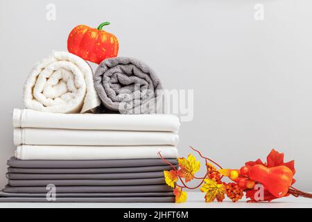 Halloween-Dekor. Grau-weiße Bettwäsche, ein Laken und zwei Handtücher auf dem Tisch. Stockfoto