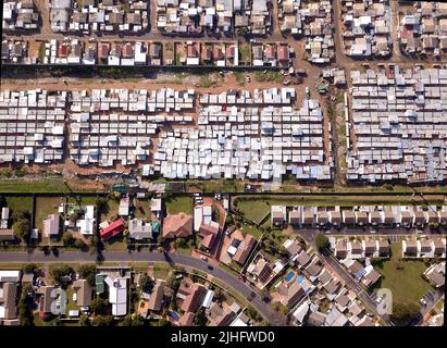 Luftaufnahme über Township und wohlhabenden Vorort in Südafrika Stockfoto