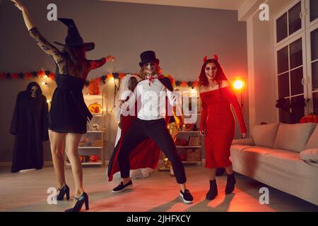 Fröhliche junge Freunde tanzen und haben Spaß zusammen auf der festlichen Party an Halloween-Nacht Stockfoto