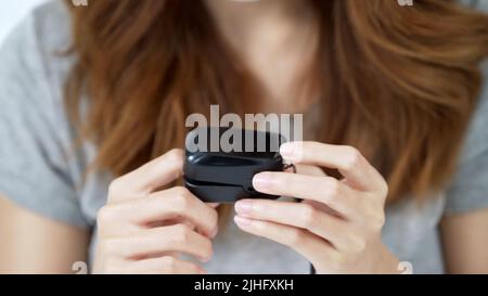 Eine Nahaufnahme des Fingers einer Frau in einem schwarzen Pulsoximeter zur Überprüfung des Blutsauerstoffs Stockfoto