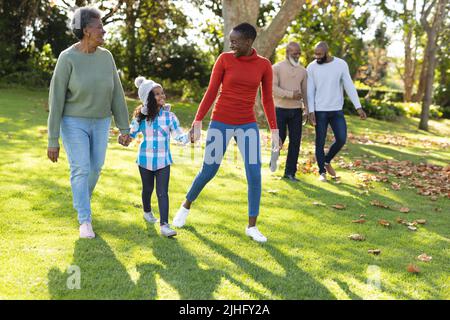Bild von glücklicher afroamerikanischer Familie mit mehreren Generationen, die Zeit im Herbstgarten verbringt Stockfoto