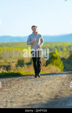 Jogging Mann Joggen in ländlicher Natur an schönen Sommertag. Sport Fitness Modell kaukasischen Ethnizität Training im Freien. Stockfoto