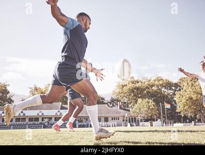 Mixed Race Rugby-Spieler, der während eines Rugby-Spiels draußen auf dem Spielfeld einen dropkick versucht. Hispanischer Mann tritt wegen Berührung oder versucht, drei Punkte zu erzielen Stockfoto