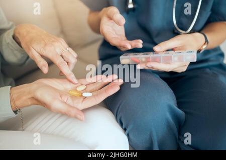 Nahaufnahme eines nicht erkennbaren Arztes, der seinen Patienten während der Genesung unterstützt. Ein liebevoller unbekannter Arzt, der Medikamente hält und die Dosierung erklärt Stockfoto
