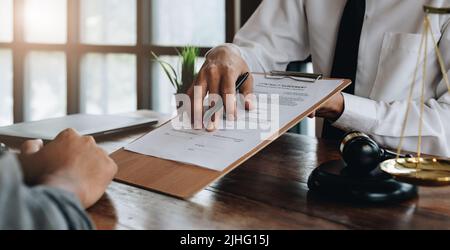 Rechtsberater, Notar oder Justizanwalt diskutieren Vertragsdokument am Schreibtisch mit Kunden in Gerichtssaal Büro, Wirtschaft, Justiz Recht Stockfoto