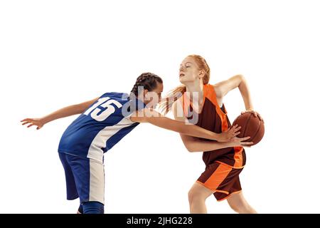 Zwei Basketballspieler, junge Mädchen, Teenager spielen Basketball isoliert auf weißem Hintergrund. Konzept von Sport, Team, wütend, Wettbewerb, Fähigkeiten Stockfoto