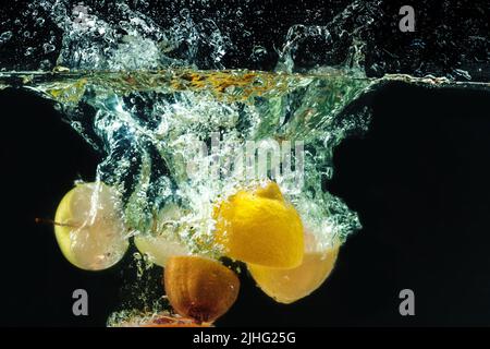 viele Früchte Spritzer ins Wasser Stockfoto