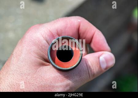 Die neue Gummidichtung wird in einer Innenverbindung des Gartenschlauchs ausgetauscht, um eine wasserdichte Kupplung zu haben. Stockfoto