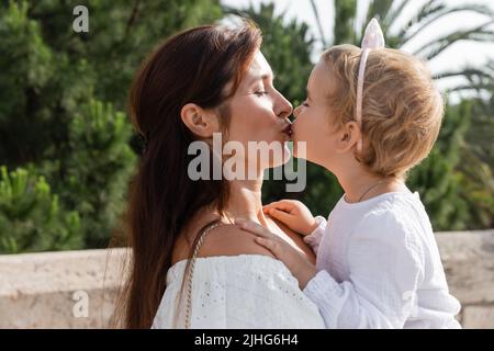 Seitenansicht von Mutter und Kind, die sich im Freien in Valencia küssen Stockfoto