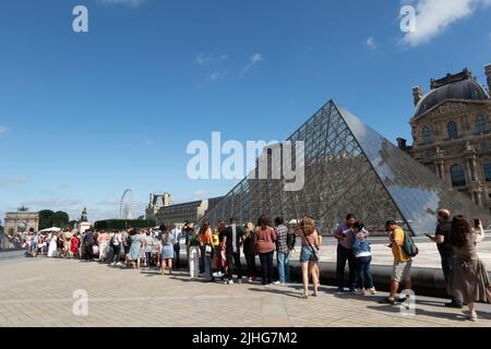 Menschen, die Schlange stehen, um das Louvre-Museum zu betreten In Paris Stockfoto