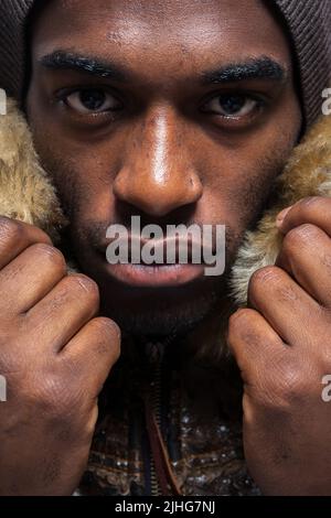 Städtischer Mann. Nahaufnahme, Augenkontakt und selbstbewusster Ausdruck eines jungen schwarzen männlichen Models. Aus einer Serie von Bildern mit demselben Modell. Stockfoto