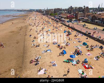 Edinburgh, Schottland, Großbritannien. 18. Juli 2022. Sehr heißes Wetter in Schottland mit Temperaturen von bis zu 31C an der Ostküste. Die heißen Temperaturen brachten Tausende von Sonnenanbetern an die Strände entlang der schottischen Küste. Bild: Der beliebte Portobello-Strand außerhalb von Edinburgh war sehr voll. Iain Masterton/Alamy Live News Stockfoto